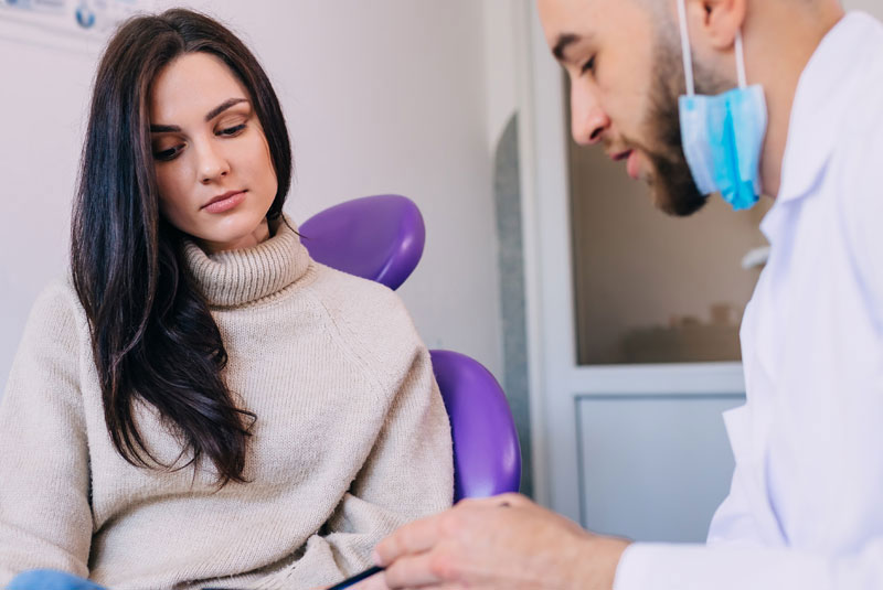 beautiful women looking at dentist explaining procedure