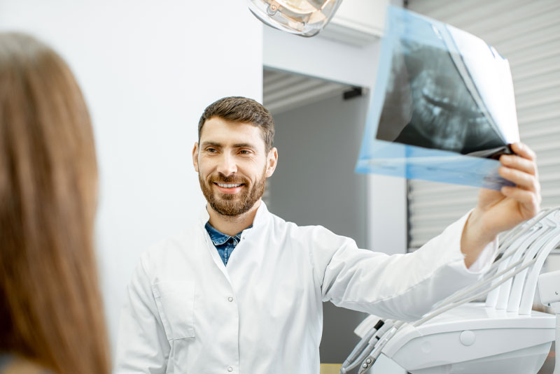 dentist with patient showing xray and going over treatment plan